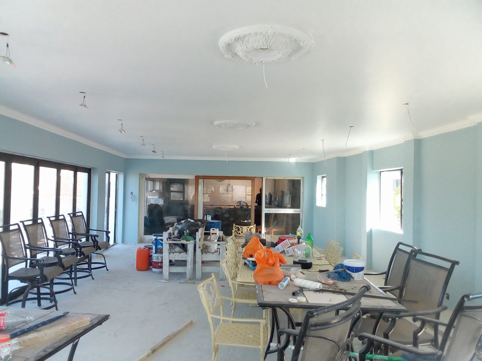 After: Interior painting Gqeberha — light blue walls, white skimmed ceiling with ornate plaster roses