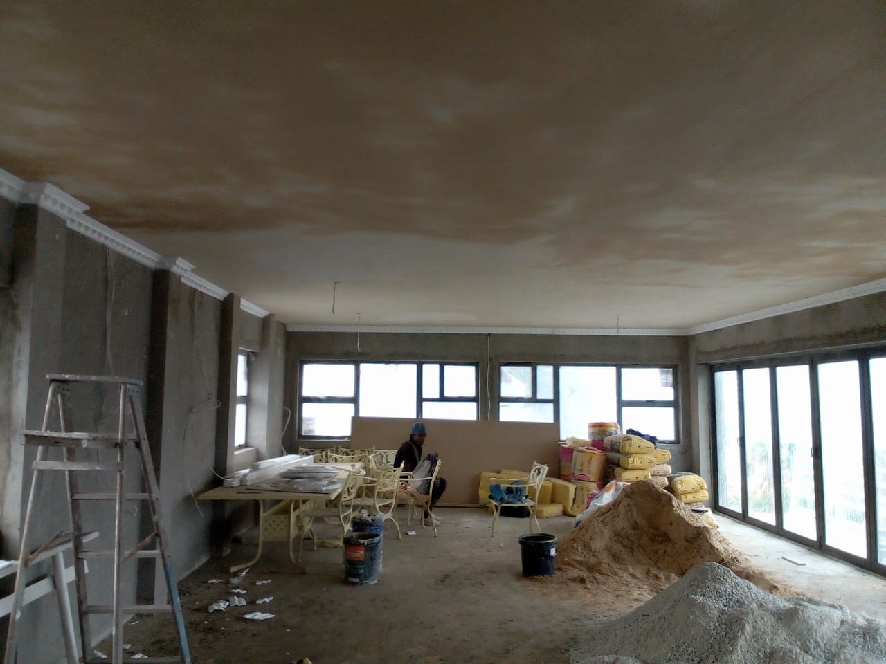 Before: Home improvements Port Elizabeth — wide interior room with raw grey plastered walls, early renovation stage